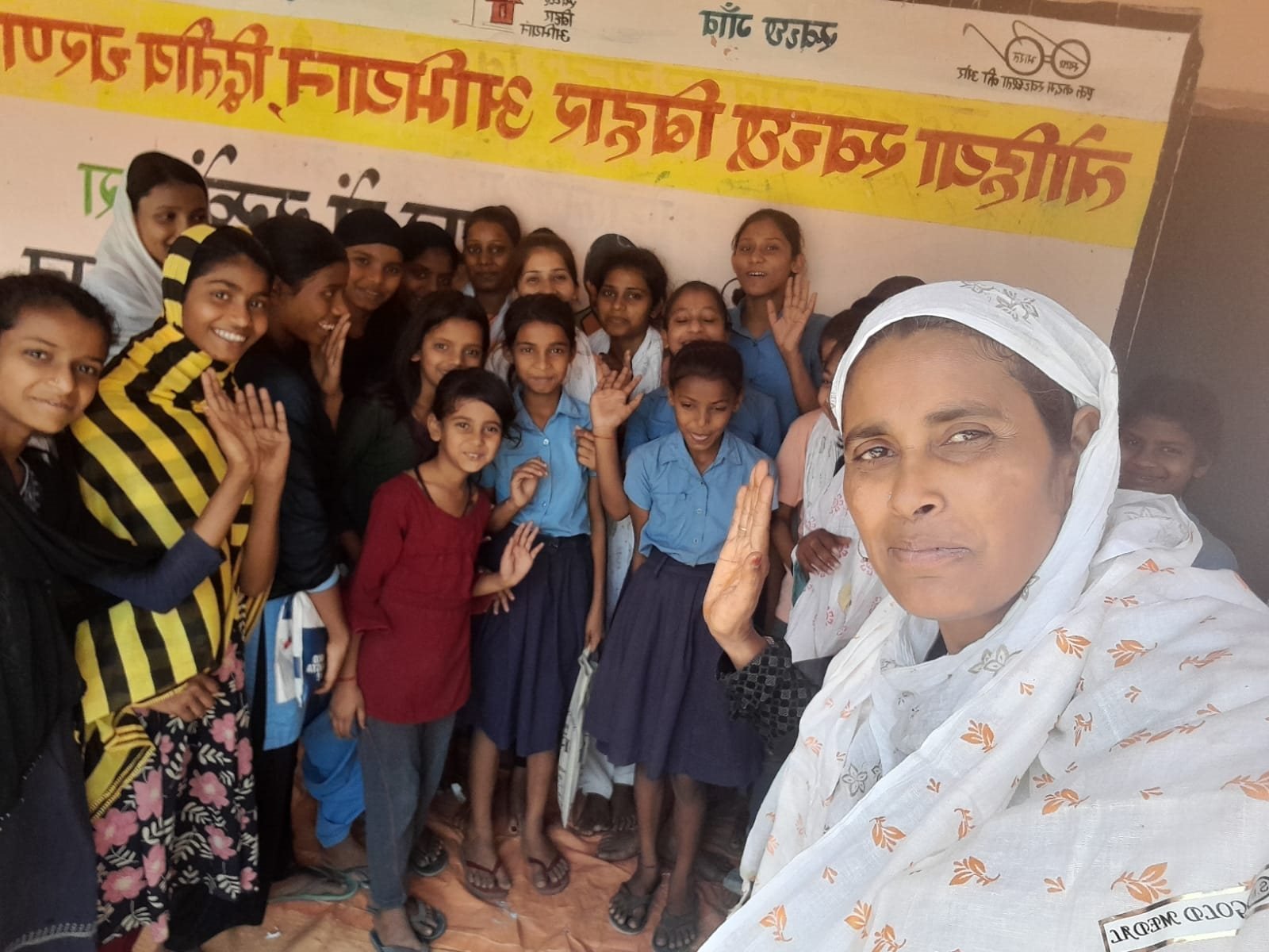 A samiti worker with a group of smiling schoolgirls after a Kala Jatha session at Supaul, April 2023.