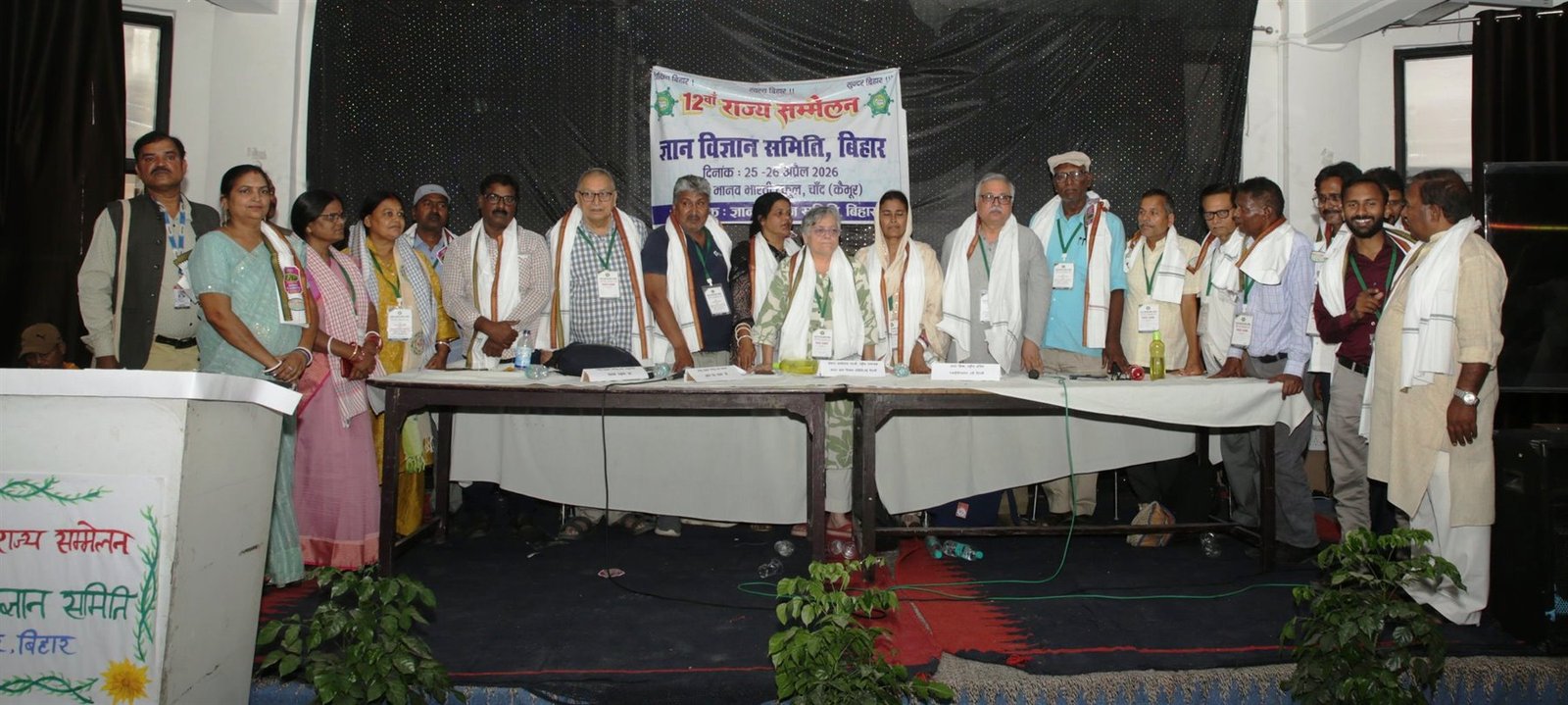 Office bearers and delegates standing together at the dais of the 12th State Conference, Chand, Kaimur, April 2026.