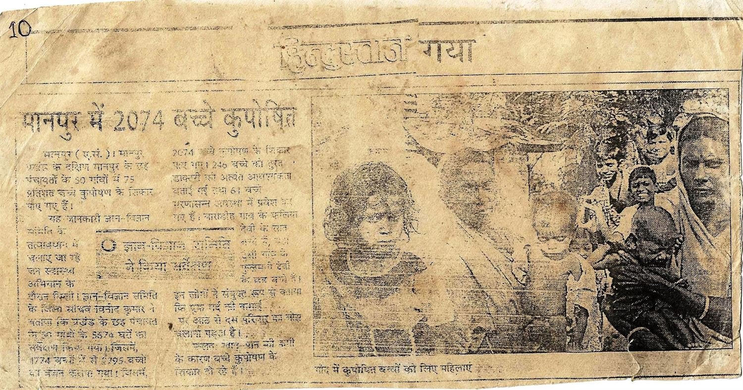 Newspaper clipping headlined 'मानपुर में 2074 बच्चे कुपोषित' with a sub-head reading 'ज्ञान-विज्ञान समिति ने किया सर्वेक्षण' and a photograph of women holding malnourished children.