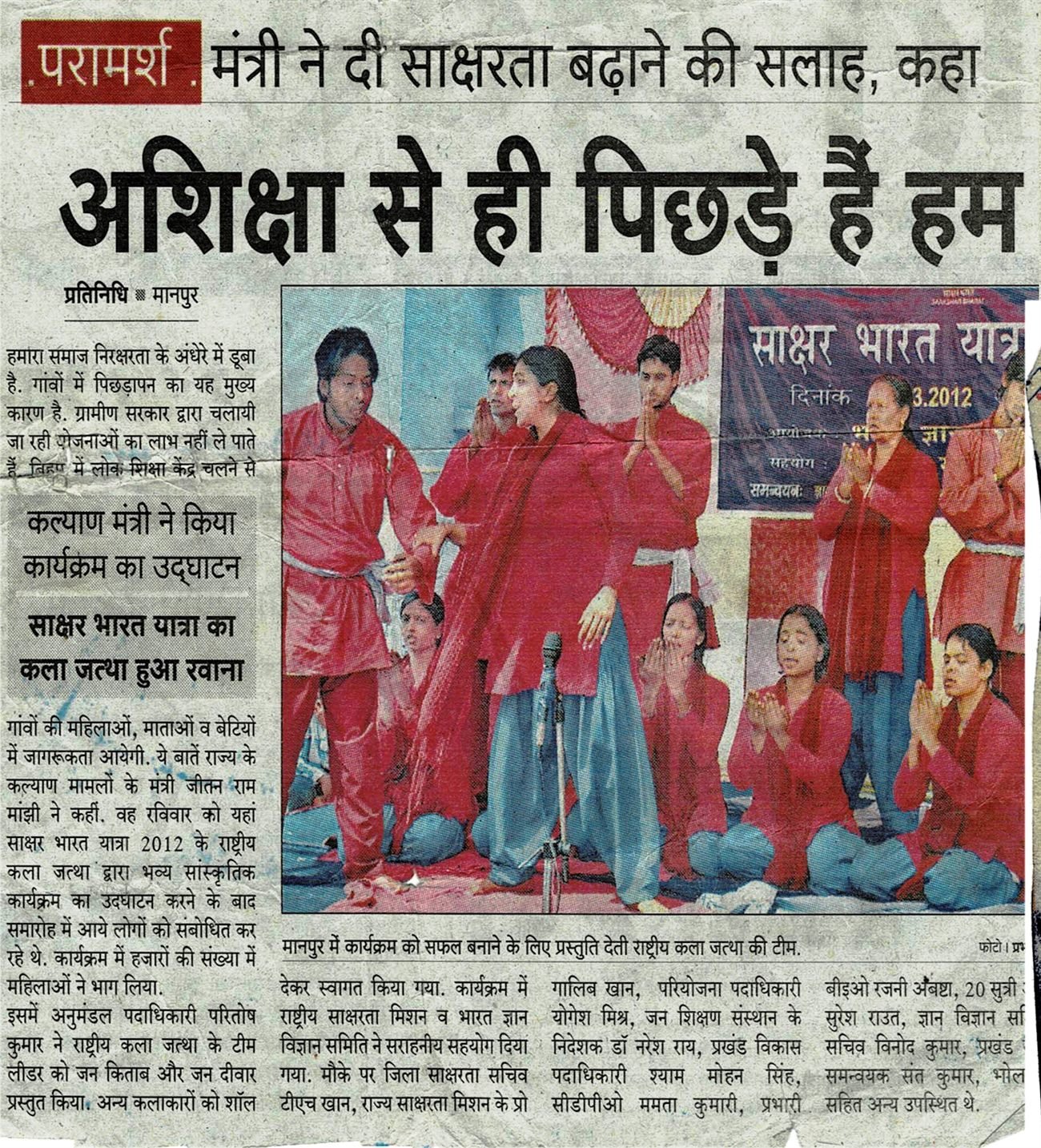 Newspaper clipping headlined 'अशिक्षा से ही पिछड़े हैं हम', with a colour photograph of the national Kala Jatha team in red costumes performing at Manpur under the Saakshar Bharat Yatra banner.
